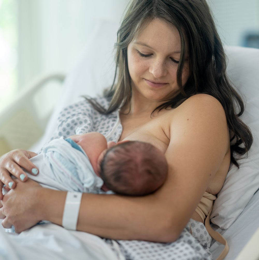 New mother nursing infant in hospital setting