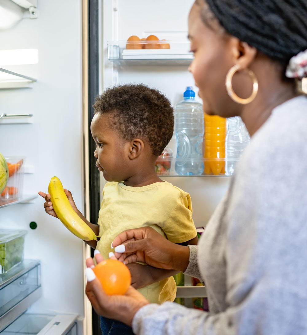 mother and her infant explore a variety of fruits