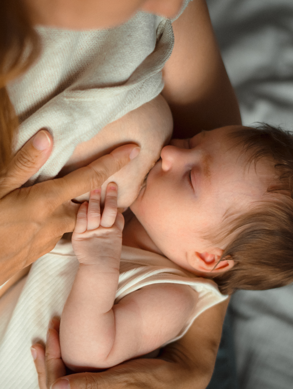 mother gently breastfeeding her infant