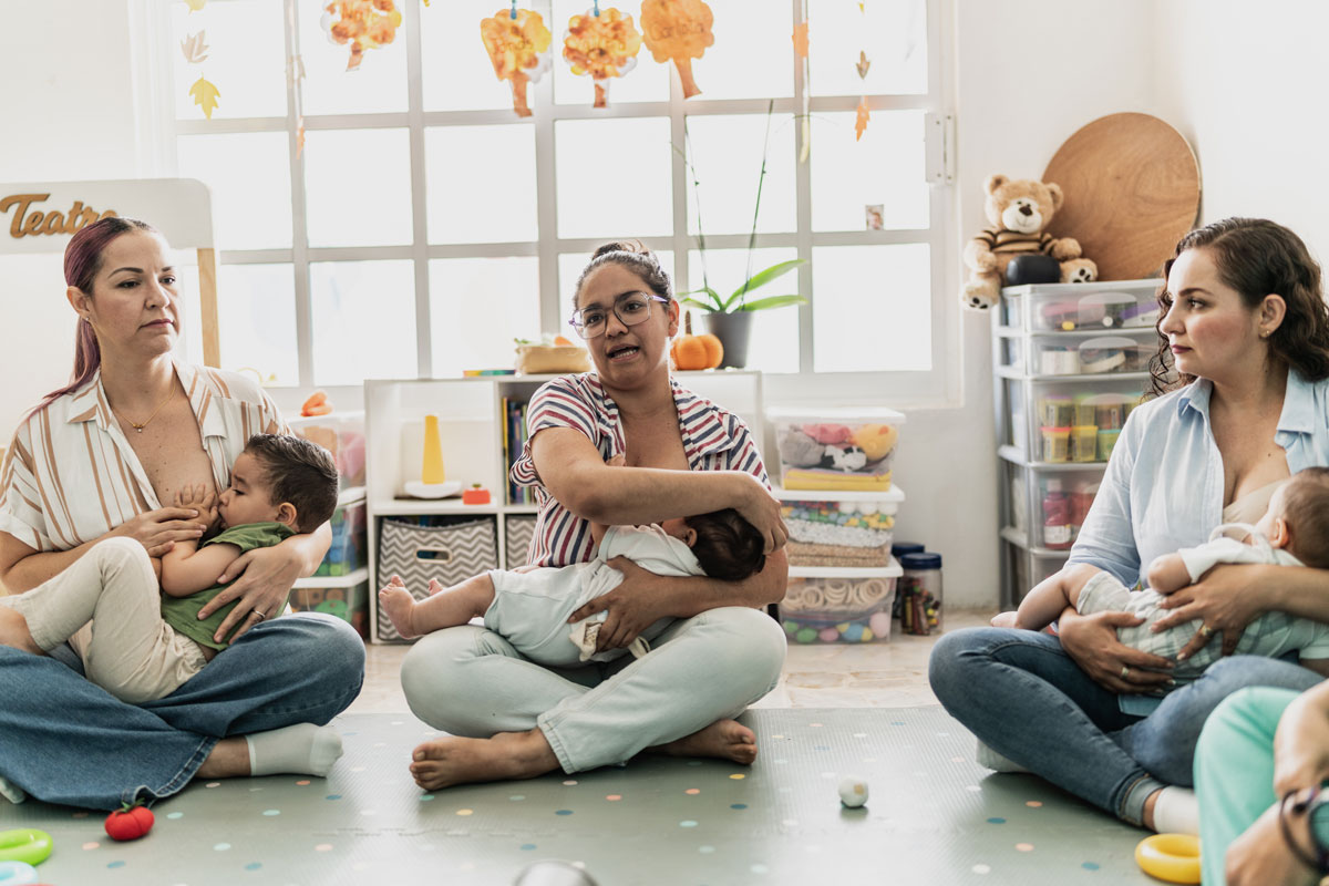 Mothers breastfeeding babies in support group session