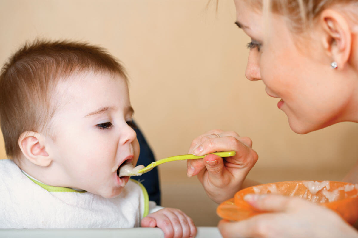 Image of Mom feeding food to child