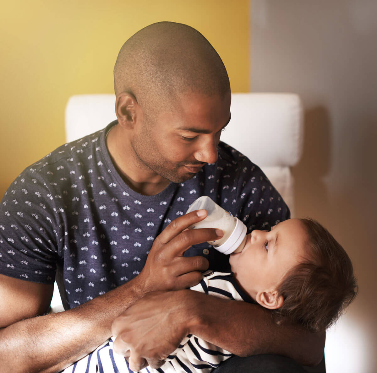 image of father feeding child milk using bottle