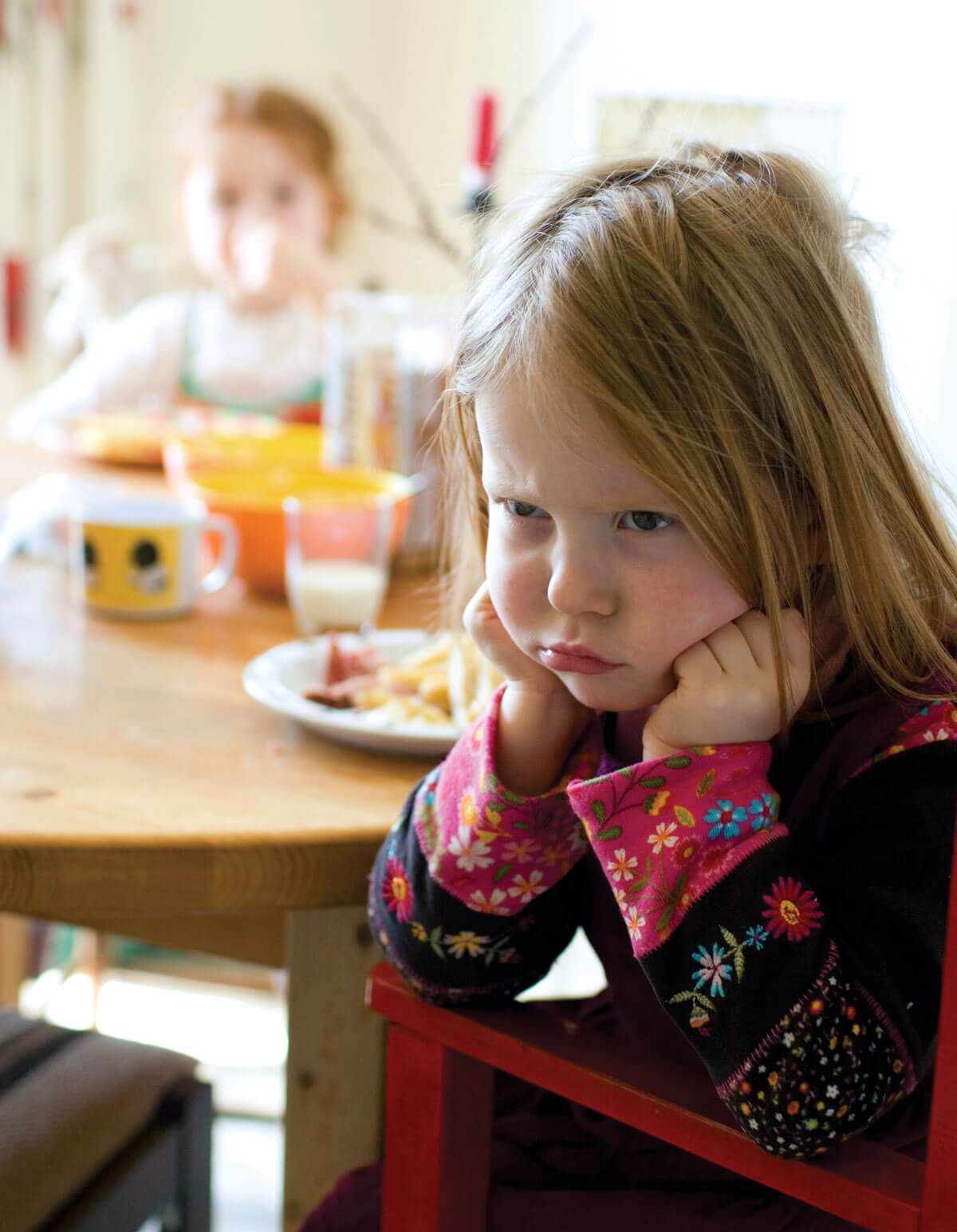A young girl sitting sadly on chair