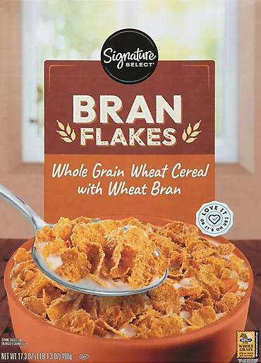 Bowl of bran flakes with spoon and milk.